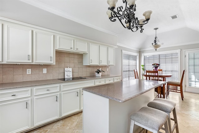3911 Misty Gardens Ct, Kingwood, TX 77339 - kitchen featuring a chandelier, decorative backsplash, white cabinetry, light tile patterned floors, and decorative light fixtures