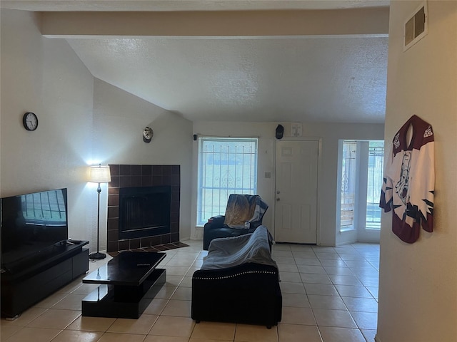 15938 Rosebriar Dr, Houston, TX 77489 - living area featuring vaulted ceiling, a fireplace, a textured ceiling, and light tile patterned floors