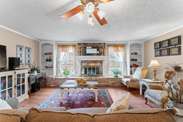 23826 Farm Hill Rd, Spring, TX 77373 - living room with a fireplace, ceiling fan, crown molding, wood finished floors, and built in features