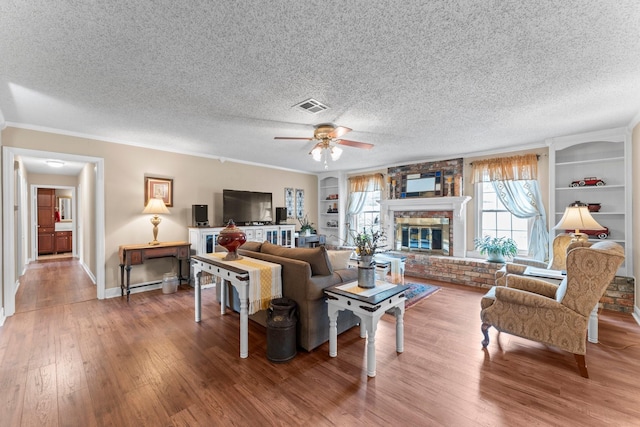 23826 Farm Hill Rd, Spring, TX 77373 - living room with a textured ceiling, wood finished floors, ceiling fan, built in shelves, and ornamental molding