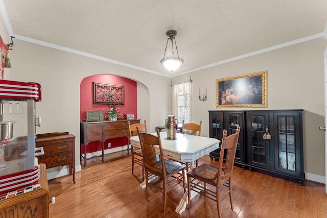 23826 Farm Hill Rd, Spring, TX 77373 - dining area featuring arched walkways, ornamental molding, wood finished floors, baseboards, and a textured ceiling