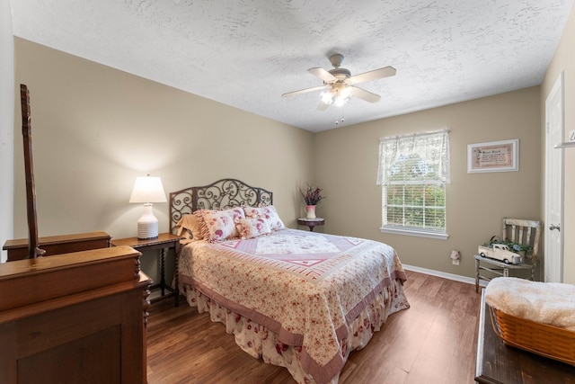 23826 Farm Hill Rd, Spring, TX 77373 - bedroom with a textured ceiling, light wood-type flooring, baseboards, and ceiling fan
