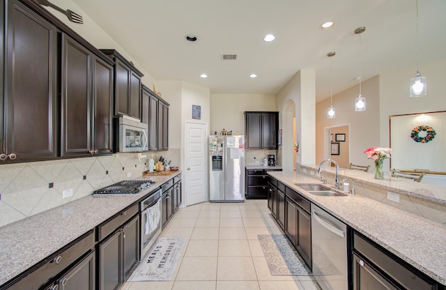4419 Rolling Field Ln, Sugar Land, TX 77479 - kitchen featuring a sink, stainless steel appliances, decorative backsplash, hanging light fixtures, and light tile patterned flooring