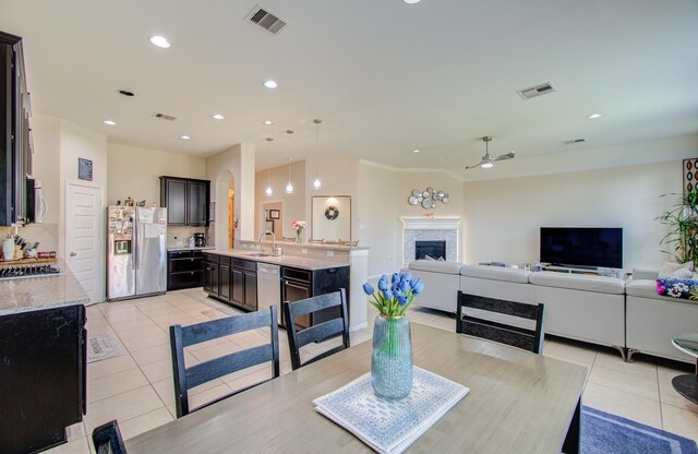 4419 Rolling Field Ln, Sugar Land, TX 77479 - dining space featuring light tile patterned flooring, a ceiling fan, a fireplace, and recessed lighting