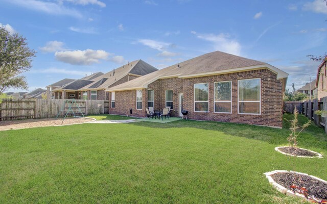4419 Rolling Field Ln, Sugar Land, TX 77479 - back of house featuring brick siding, a playground, roof with shingles, and a patio