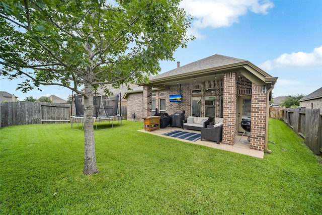 4011 Teramo Ln, Katy, TX 77493 - back of house featuring a trampoline, outdoor lounge area, a patio area, brick siding, and a shingled roof