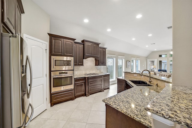 4011 Teramo Ln, Katy, TX 77493 - kitchen with stainless steel appliances, tasteful backsplash, a sink, light tile patterned floors, and dark brown cabinetry