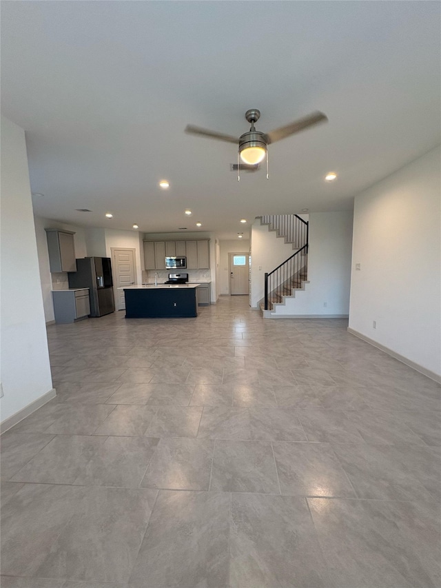 29506 Wilkerson Ln, Katy, TX 77494 - unfurnished living room with stairs, baseboards, ceiling fan, and recessed lighting