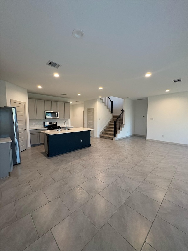 29506 Wilkerson Ln, Katy, TX 77494 - kitchen featuring stainless steel appliances, gray cabinetry, open floor plan, recessed lighting, and light countertops
