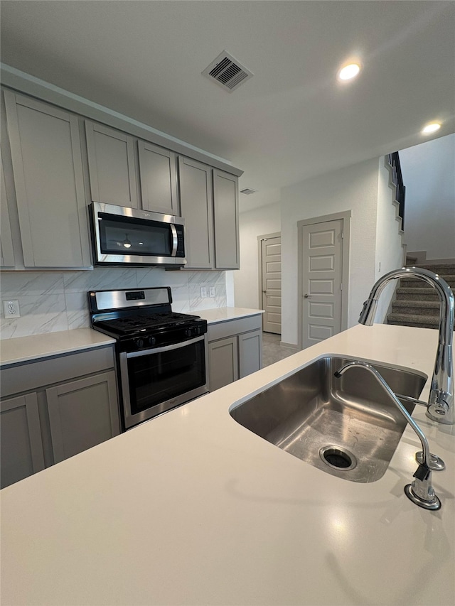 29506 Wilkerson Ln, Katy, TX 77494 - kitchen with appliances with stainless steel finishes, gray cabinets, a sink, and recessed lighting