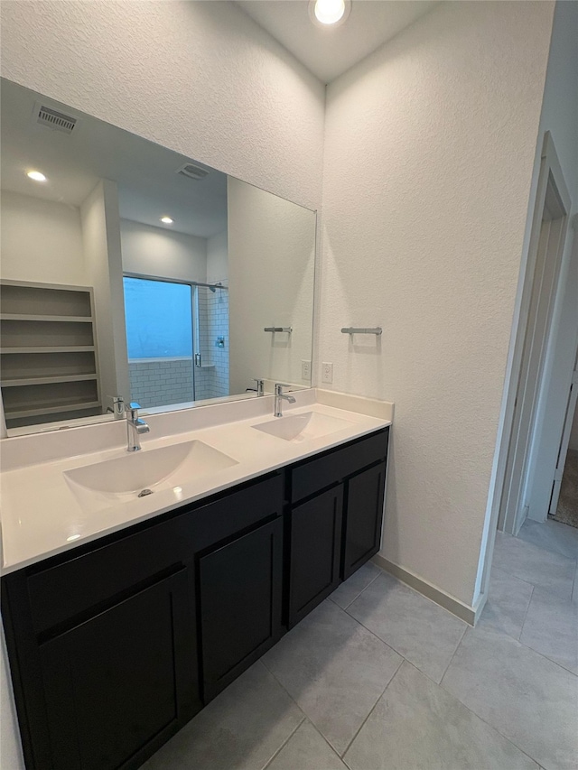 29506 Wilkerson Ln, Katy, TX 77494 - bathroom featuring double vanity, tiled shower, tile patterned floors, a textured wall, and baseboards