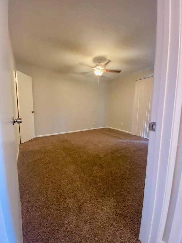 9000 Bissonnet St Unit 707, Houston, TX 77074 - unfurnished room with dark colored carpet, a ceiling fan, and baseboards