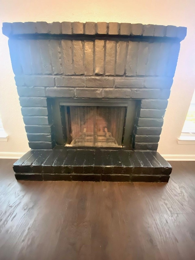 9000 Bissonnet St Unit 707, Houston, TX 77074 - detailed view of baseboards, a fireplace, and wood finished floors