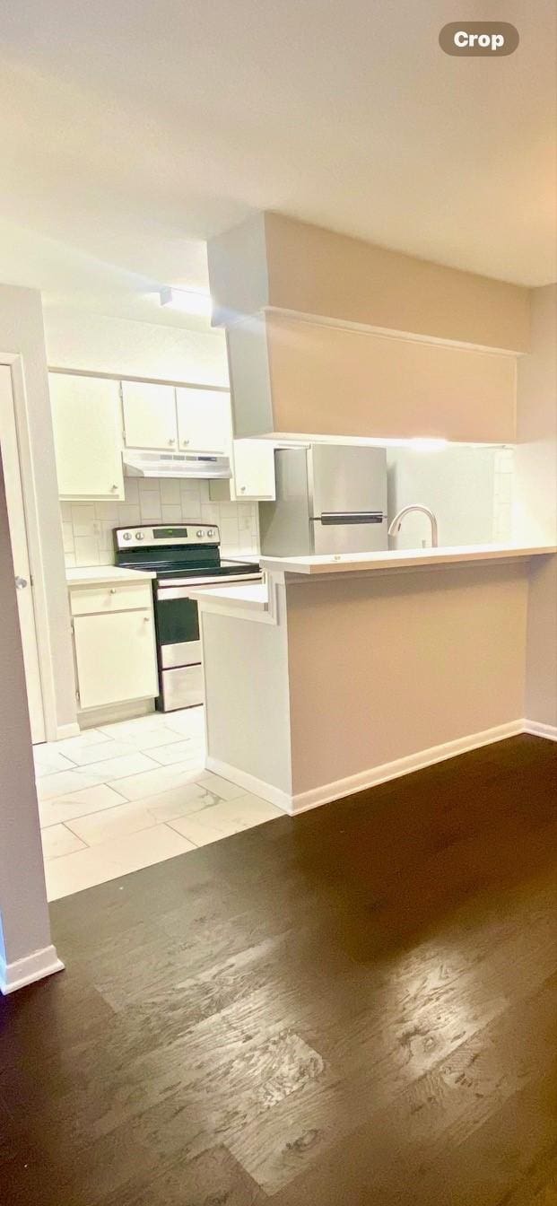 9000 Bissonnet St Unit 707, Houston, TX 77074 - kitchen with stainless steel range with electric cooktop, freestanding refrigerator, white cabinetry, under cabinet range hood, and baseboards