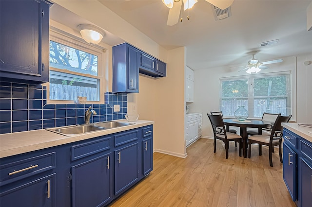 4210 Mona Lee Ln, Houston, TX 77080 - kitchen with a ceiling fan, blue cabinetry, a sink, and decorative backsplash
