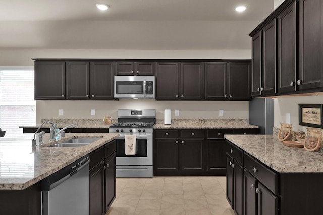9923 Berlandier Ash Ln, Tomball, TX 77375 - kitchen with appliances with stainless steel finishes, a sink, light stone counters, recessed lighting, and light tile patterned floors