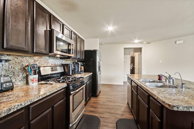 24402 Yellow Thyme Dr, Spring, TX 77373 - kitchen featuring stainless steel appliances, a sink, dark brown cabinetry, backsplash, and recessed lighting
