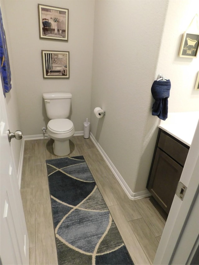 14827 Fairy Tern Ln, Houston, TX 77049 - half bath with toilet, vanity, baseboards, and wood finish floors