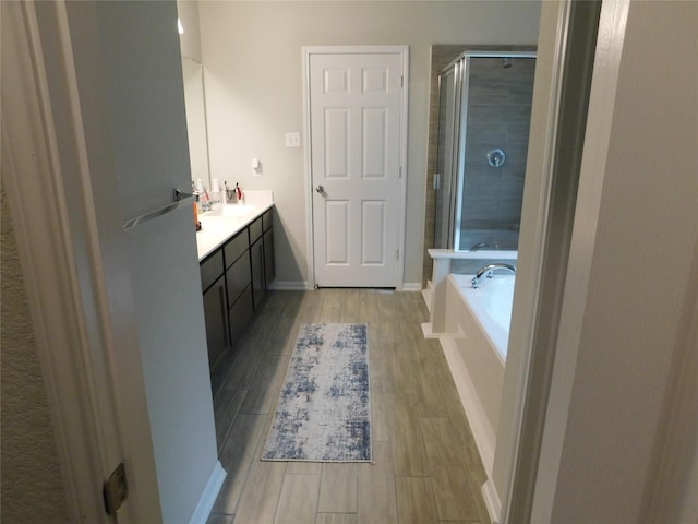 14827 Fairy Tern Ln, Houston, TX 77049 - full bathroom featuring vanity, a shower stall, wood finished floors, a bath, and baseboards