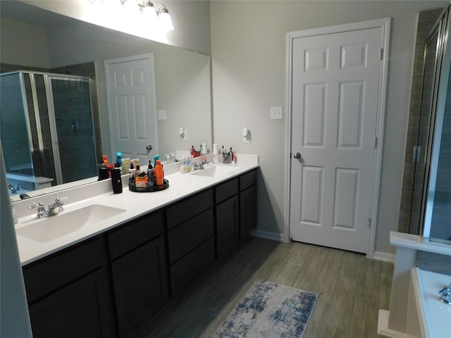 14827 Fairy Tern Ln, Houston, TX 77049 - bathroom with a stall shower, double vanity, wood finished floors, and a tub