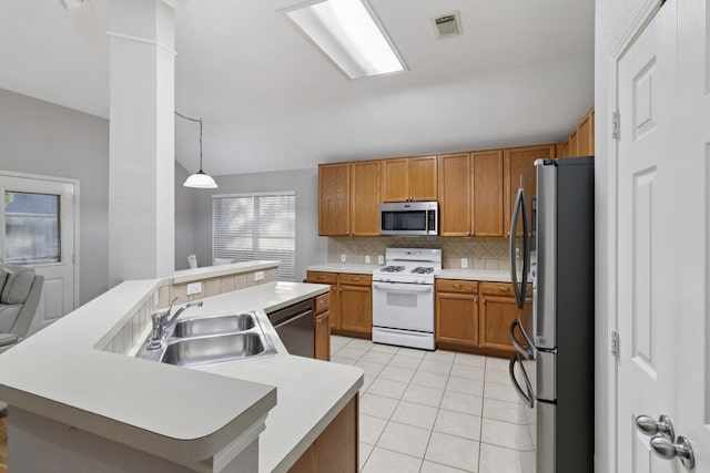 5023 Rocky Manor Ln, Katy, TX 77449 - kitchen featuring appliances with stainless steel finishes, a sink, tasteful backsplash, brown cabinets, and light countertops