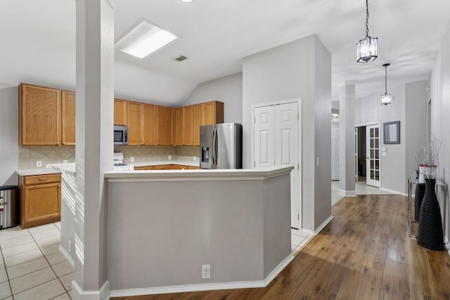 5023 Rocky Manor Ln, Katy, TX 77449 - kitchen with stainless steel appliances, light countertops, backsplash, light wood-type flooring, and vaulted ceiling