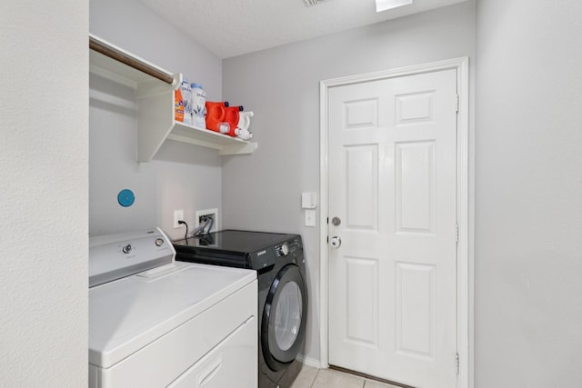 5023 Rocky Manor Ln, Katy, TX 77449 - laundry area featuring washing machine and clothes dryer and light tile patterned flooring