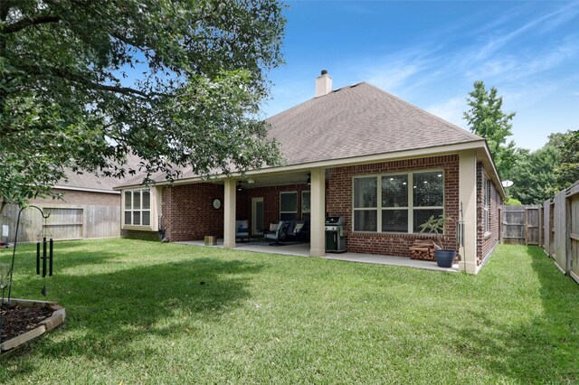 266 Overland Trce, Montgomery, TX 77316 - back of house featuring brick siding, a chimney, a patio, and a shingled roof