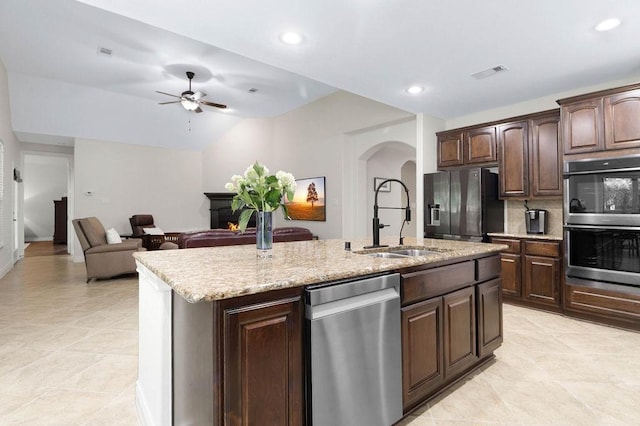 266 Overland Trce, Montgomery, TX 77316 - kitchen featuring stainless steel appliances, a sink, arched walkways, an island with sink, and a ceiling fan