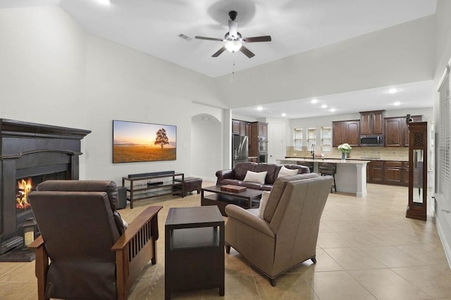 266 Overland Trce, Montgomery, TX 77316 - living room with ceiling fan, a lit fireplace, recessed lighting, light tile patterned flooring, and high vaulted ceiling