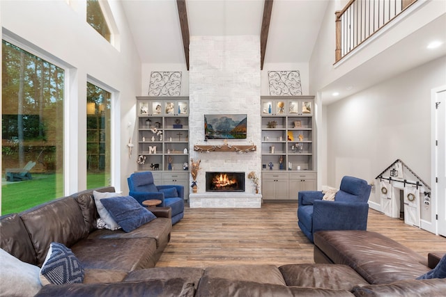 19817 Whispering Creek Trl, Magnolia, TX 77355 - living area with high vaulted ceiling, wood finished floors, a fireplace, beamed ceiling, and baseboards