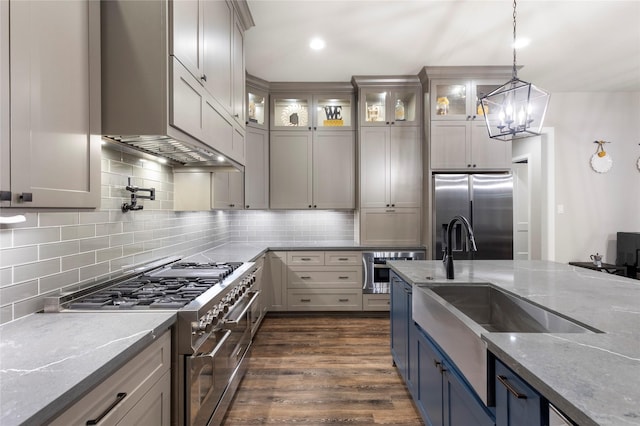 19817 Whispering Creek Trl, Magnolia, TX 77355 - kitchen featuring stainless steel appliances, light stone countertops, backsplash, a sink, and glass insert cabinets