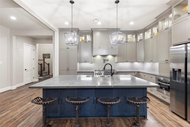 19817 Whispering Creek Trl, Magnolia, TX 77355 - kitchen with stainless steel fridge with ice dispenser, a chandelier, a sink, tasteful backsplash, and oven