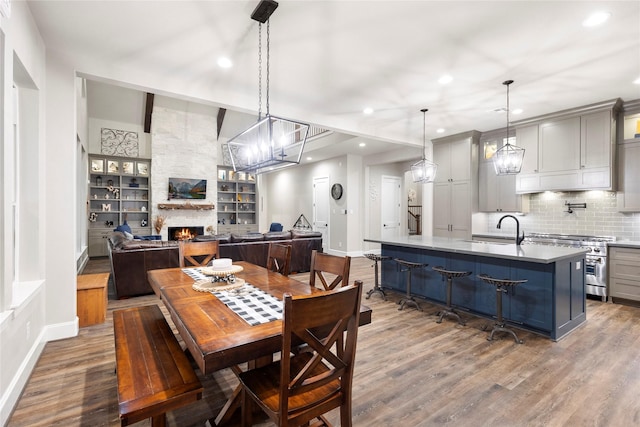 19817 Whispering Creek Trl, Magnolia, TX 77355 - dining room with baseboards, a stone fireplace, recessed lighting, dark wood-style flooring, and built in features