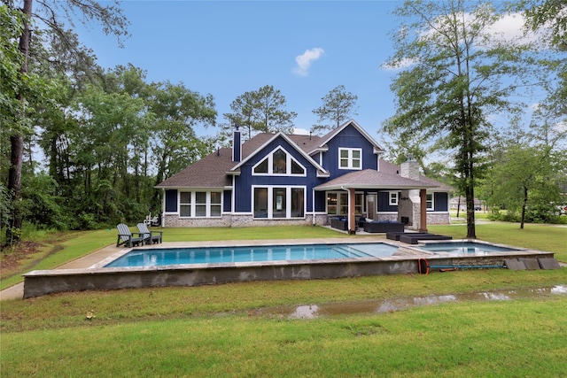 19817 Whispering Creek Trl, Magnolia, TX 77355 - back of property featuring a chimney, an in-ground hot tub, an outdoor pool, stone siding, and a yard