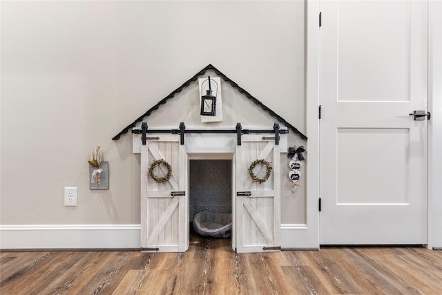 19817 Whispering Creek Trl, Magnolia, TX 77355 - detailed view of wood finished floors, a barn door, and baseboards