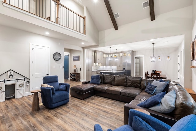 19817 Whispering Creek Trl, Magnolia, TX 77355 - living area featuring high vaulted ceiling, wood finished floors, beam ceiling, a chandelier, and baseboards