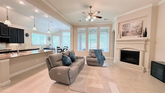 3021 Rocky Point Dr, Pearland, TX 77584 - living area with light tile patterned floors, a ceiling fan, a fireplace with raised hearth, recessed lighting, and crown molding