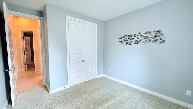 3021 Rocky Point Dr, Pearland, TX 77584 - unfurnished bedroom featuring a closet, light carpet, and baseboards