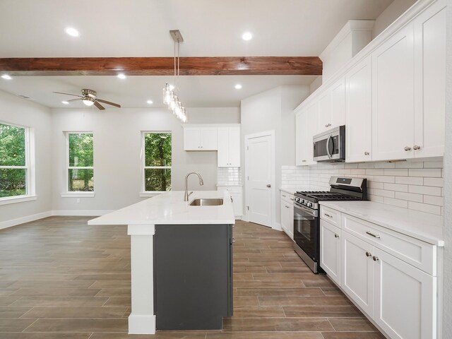 731 Magnolia Point Dr, Houston, TX 77336 - kitchen featuring appliances with stainless steel finishes, a sink, beamed ceiling, dark wood-style flooring, and recessed lighting