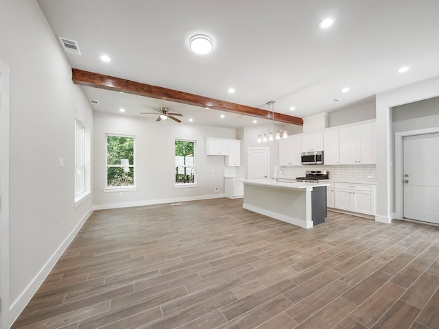 731 Magnolia Point Dr, Houston, TX 77336 - kitchen featuring stainless steel appliances, beamed ceiling, a sink, a ceiling fan, and white cabinetry