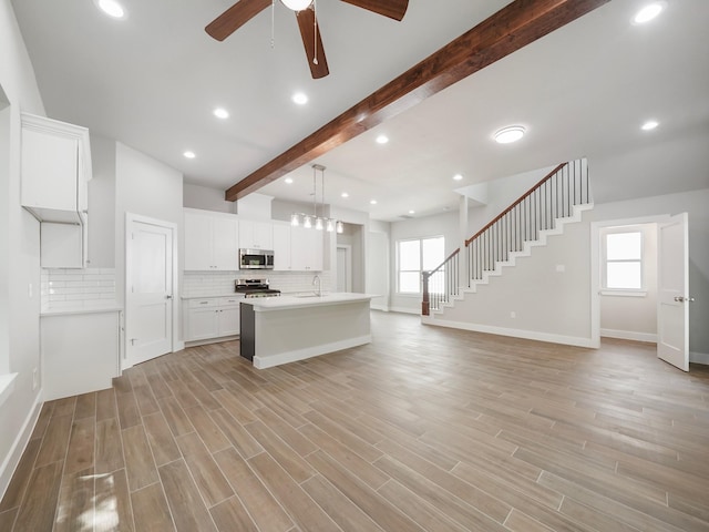 731 Magnolia Point Dr, Houston, TX 77336 - kitchen featuring appliances with stainless steel finishes, open floor plan, a ceiling fan, beamed ceiling, and a sink