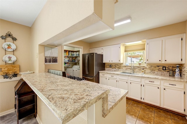 2465 Ryan Dr, Alvin, TX 77511 - kitchen with freestanding refrigerator, a sink, washer and clothes dryer, backsplash, and light countertops