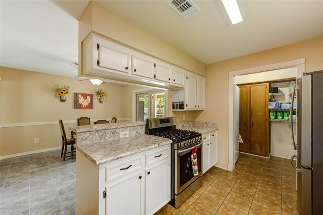 2465 Ryan Dr, Alvin, TX 77511 - kitchen with appliances with stainless steel finishes, a peninsula, white cabinetry, baseboards, and light stone counters