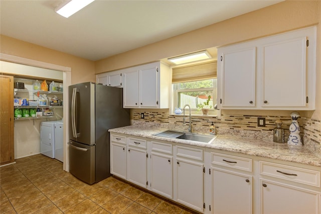 2465 Ryan Dr, Alvin, TX 77511 - kitchen featuring washing machine and dryer, a sink, freestanding refrigerator, and decorative backsplash