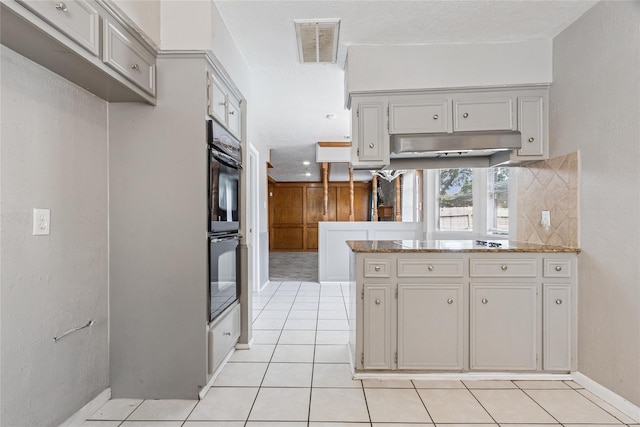 15623 Ensenada Dr, Houston, TX 77083 - kitchen featuring light tile patterned floors, a peninsula, electric cooktop, and under cabinet range hood