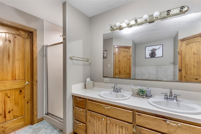 881 County Road 2276, Cleveland, TX 77327 - full bathroom featuring double vanity, a stall shower, and a textured ceiling