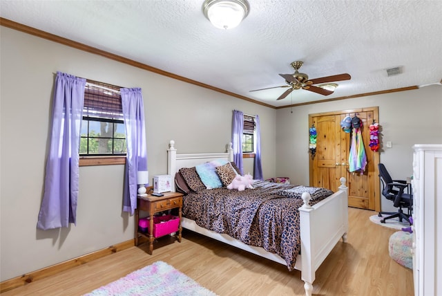 881 County Road 2276, Cleveland, TX 77327 - bedroom featuring light wood-type flooring, a textured ceiling, crown molding, baseboards, and a ceiling fan