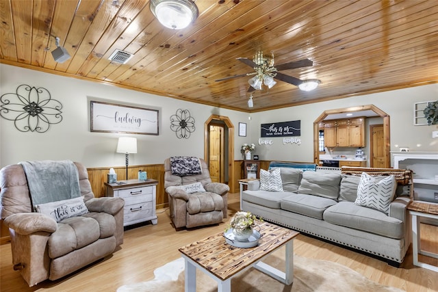 881 County Road 2276, Cleveland, TX 77327 - living area with arched walkways, wooden ceiling, crown molding, ceiling fan, and a wainscoted wall