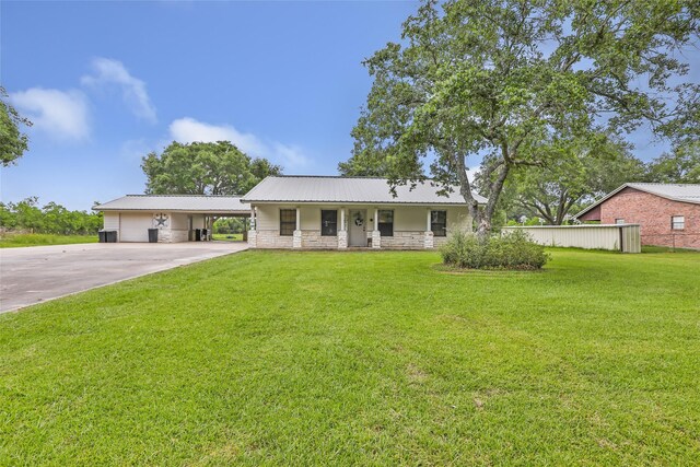 881 County Road 2276, Cleveland, TX 77327 - single story home featuring a carport, concrete driveway, a front lawn, covered porch, and metal roof
